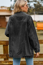 Black oversized denim trucker jacket with classic details and buttoned cuffs.