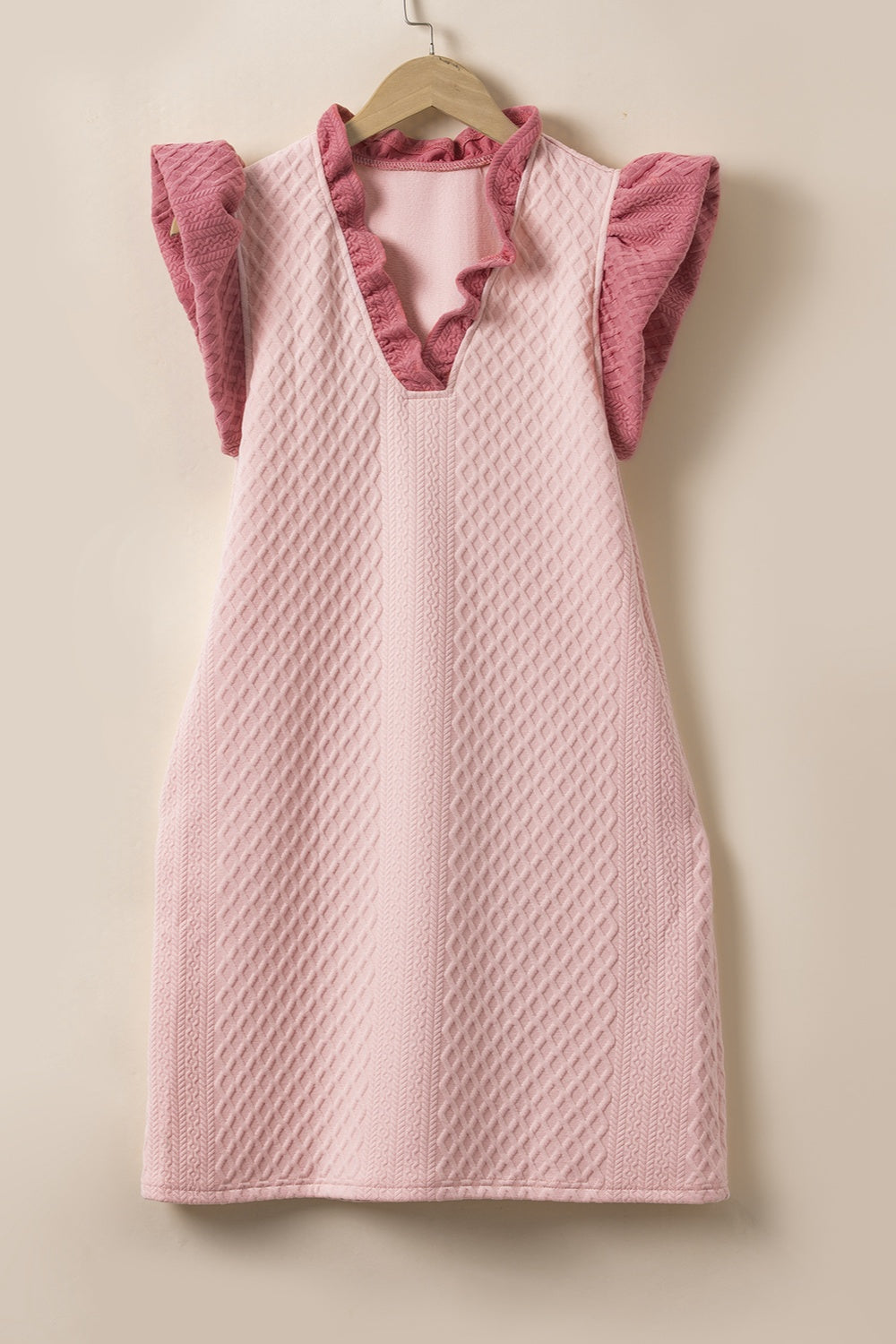 Blush pink trapeze dress with textured diamond pattern, ruffle neckline and sleeves.