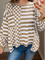 Asymmetrical checkered patchwork knit top in camel and white with crew neck and long sleeves.