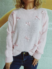 Blush pink knit crewneck sweater with scattered satin bows, crew neck, long sleeves.