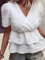 White textured surplice tiered blouse with short puff sleeves and V-neck.