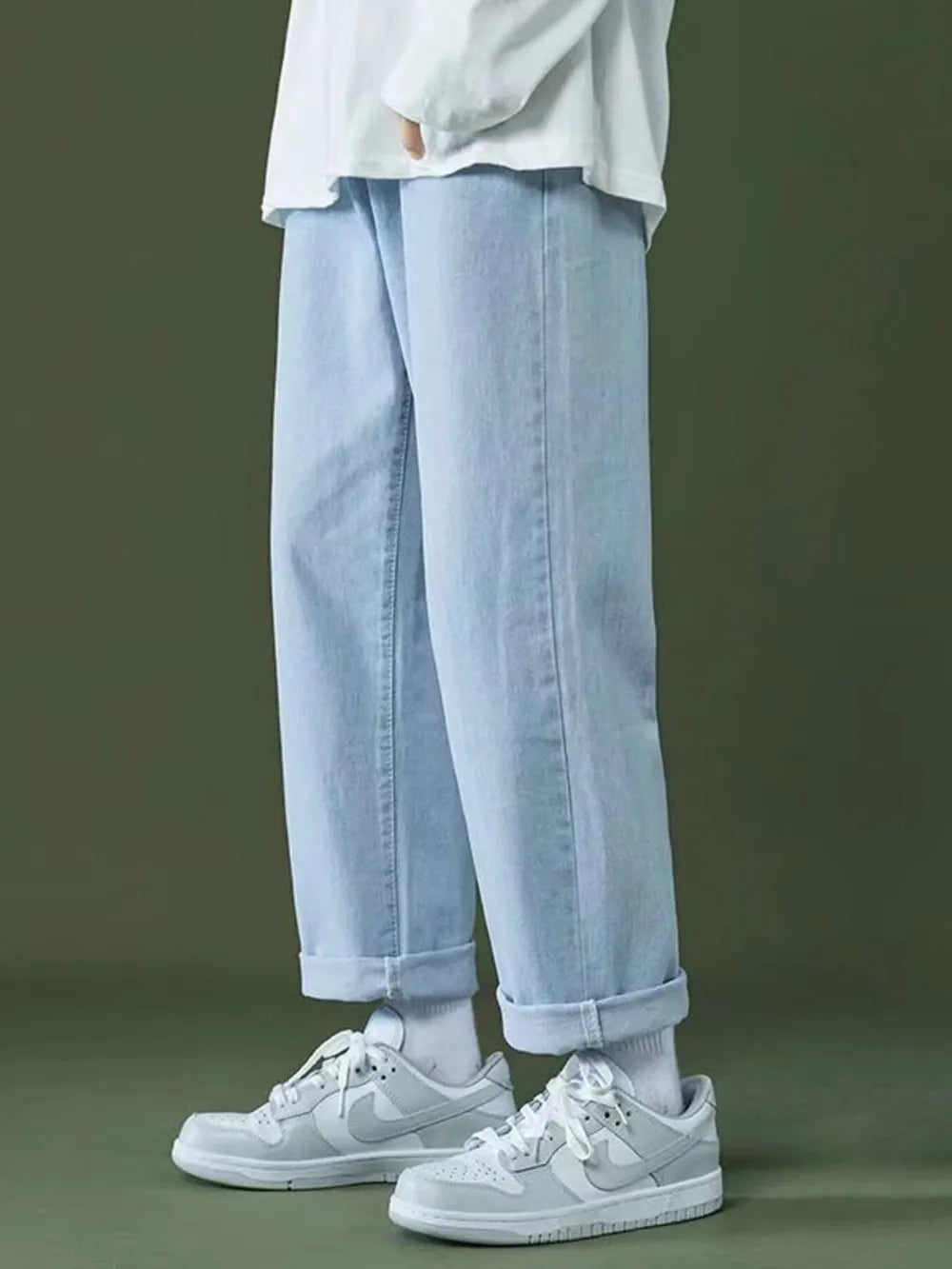 Casual oversized light wash men's jeans with cuffed hems and pockets.