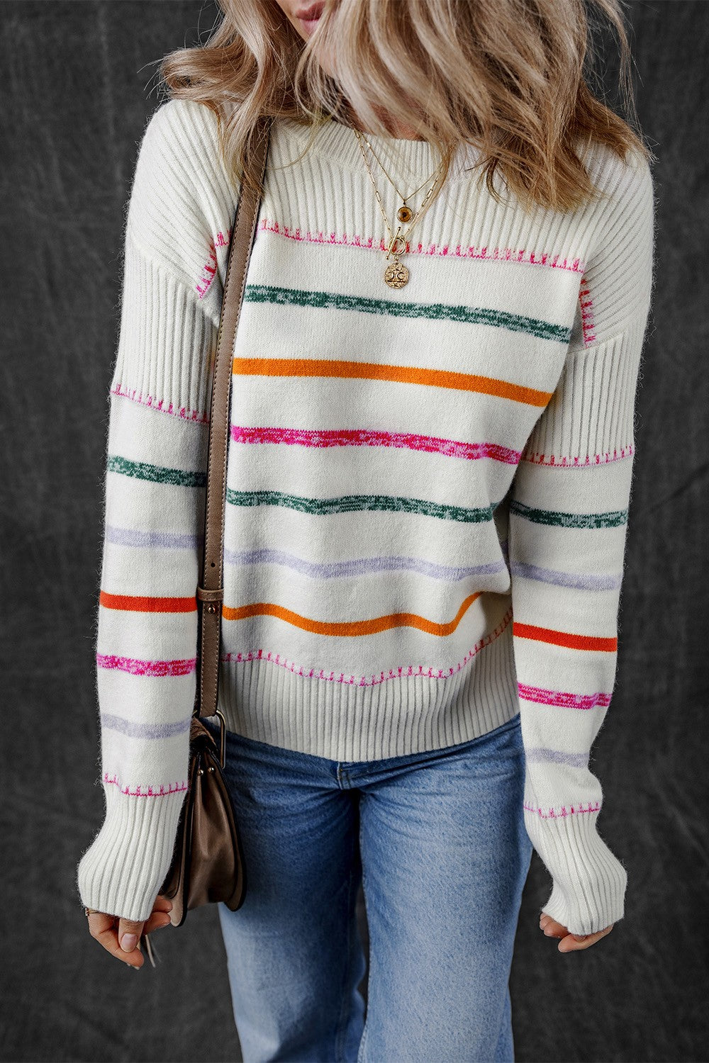 White ribbed knit pullover sweater with rainbow stripes and crew neck.