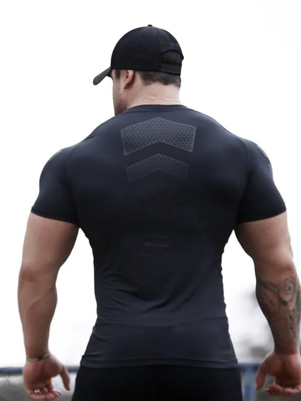 Black performance mesh sculpt tee with chevron detail on back.