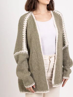 Oversized sage green knit cardigan with white contrast trim and open front.