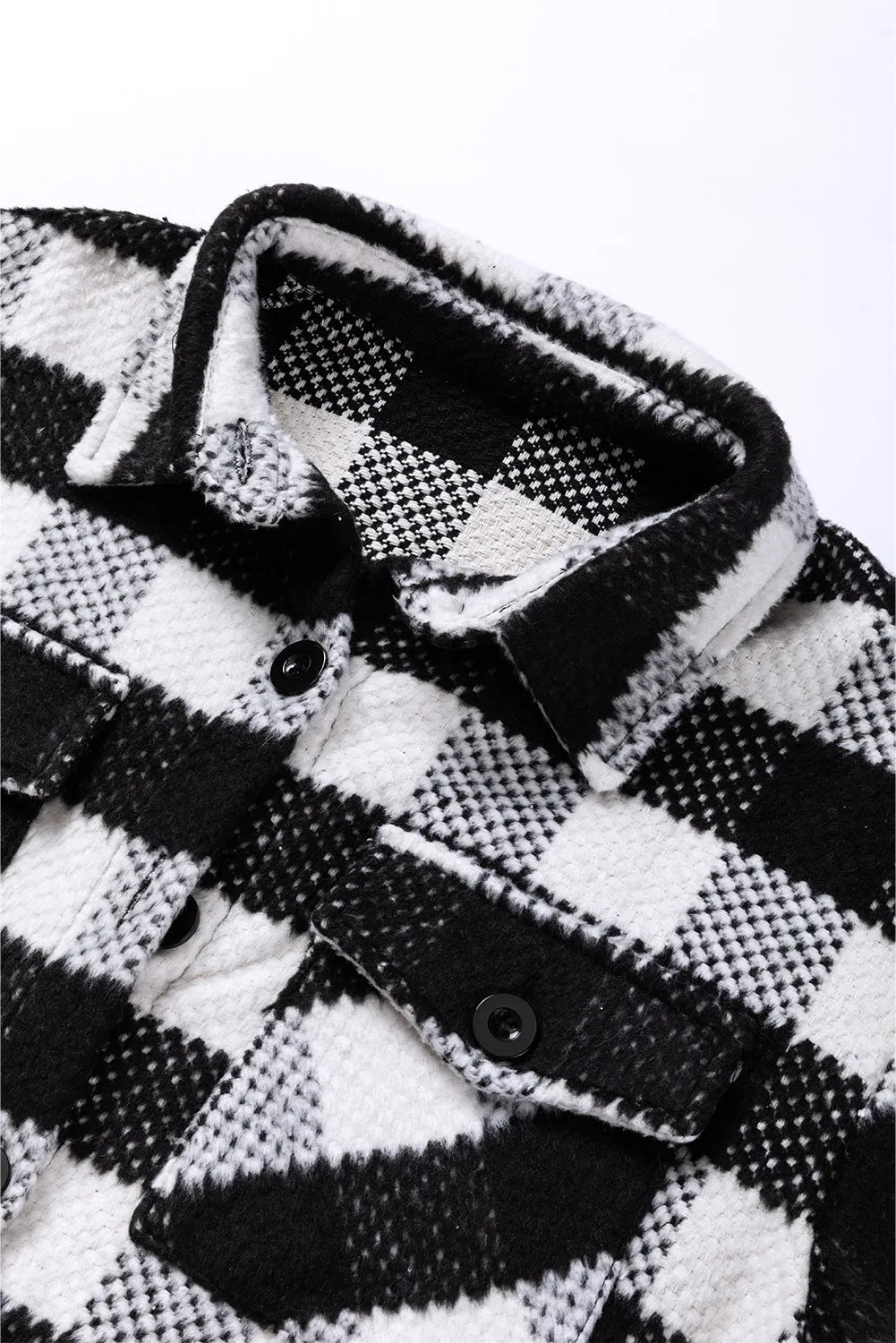 Textured checkerboard overshirt in plaid black and white with button closure and chest pockets.