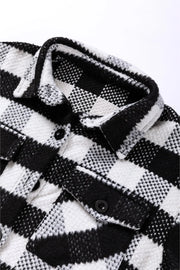 Textured checkerboard overshirt in plaid black and white with button closure and chest pockets.