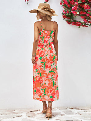 Floral print midi dress in red-violet and orange with spaghetti straps and a cinched waist.