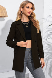 Black double-breasted blazer with flap pockets and notched lapels, worn open over a crop top.