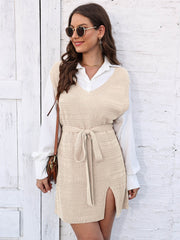 Cream knit vest dress with V-neck, tie waist, and side slit, worn over a white shirt.