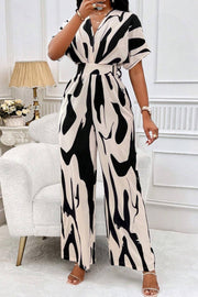 Abstract brushstroke wide-leg jumpsuit in black and beige with short sleeves and a V-neck.