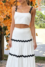 White crop top and tiered skirt set with black scalloped trim detail.