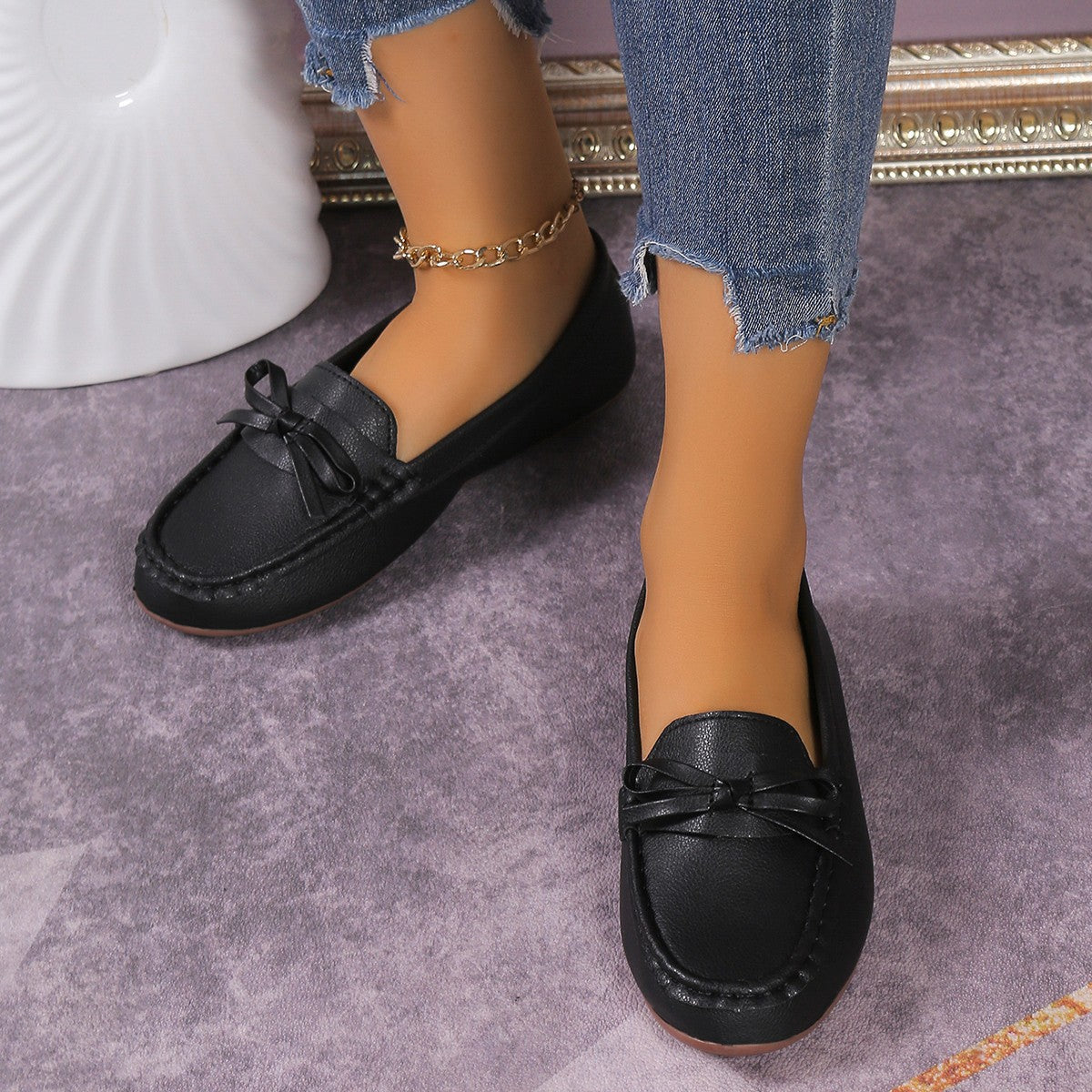 Black bow embellished flat slip-on loafers with a comfortable casual style.