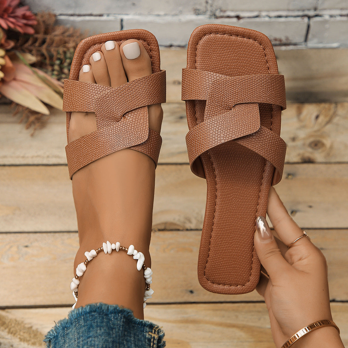 Brown textured crisscross strap flat sandals with a square toe.