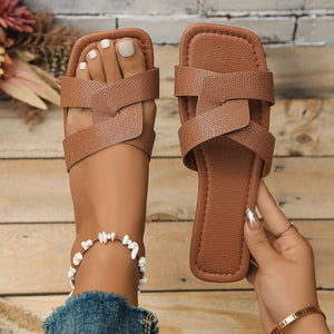 Brown textured crisscross strap flat sandals with a square toe.