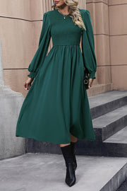 Dark green polyester midi dress with smocked bodice and balloon sleeves.