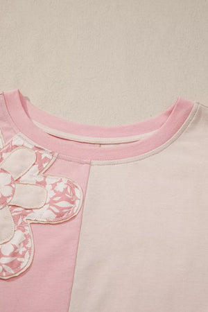Maternity t-shirt with pink and cream color block, featuring a dimensional applique flower detail.