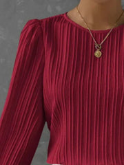 Burgundy pleated blouse with gathered shoulder detail and long sleeves.