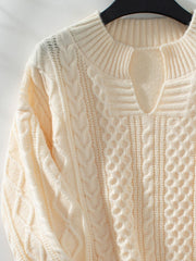 Cream cable knit sweater with keyhole neckline and ribbed trim.