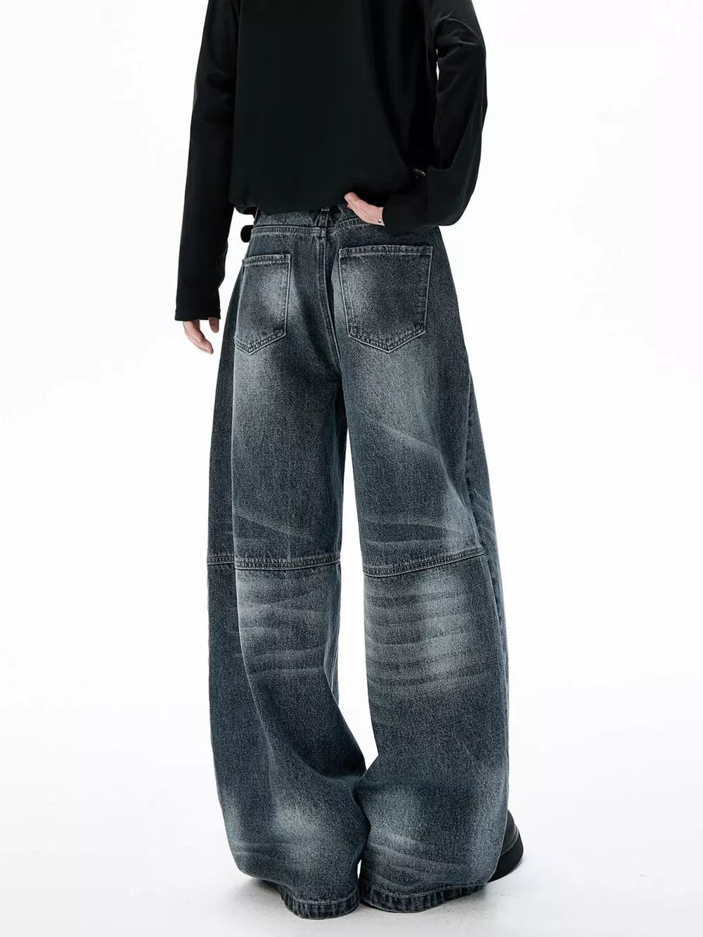Belted wide-leg jeans in dark wash denim with unique paneled design and baggy fit.