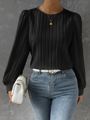 Black pleated blouse with gathered shoulders and long sleeves.