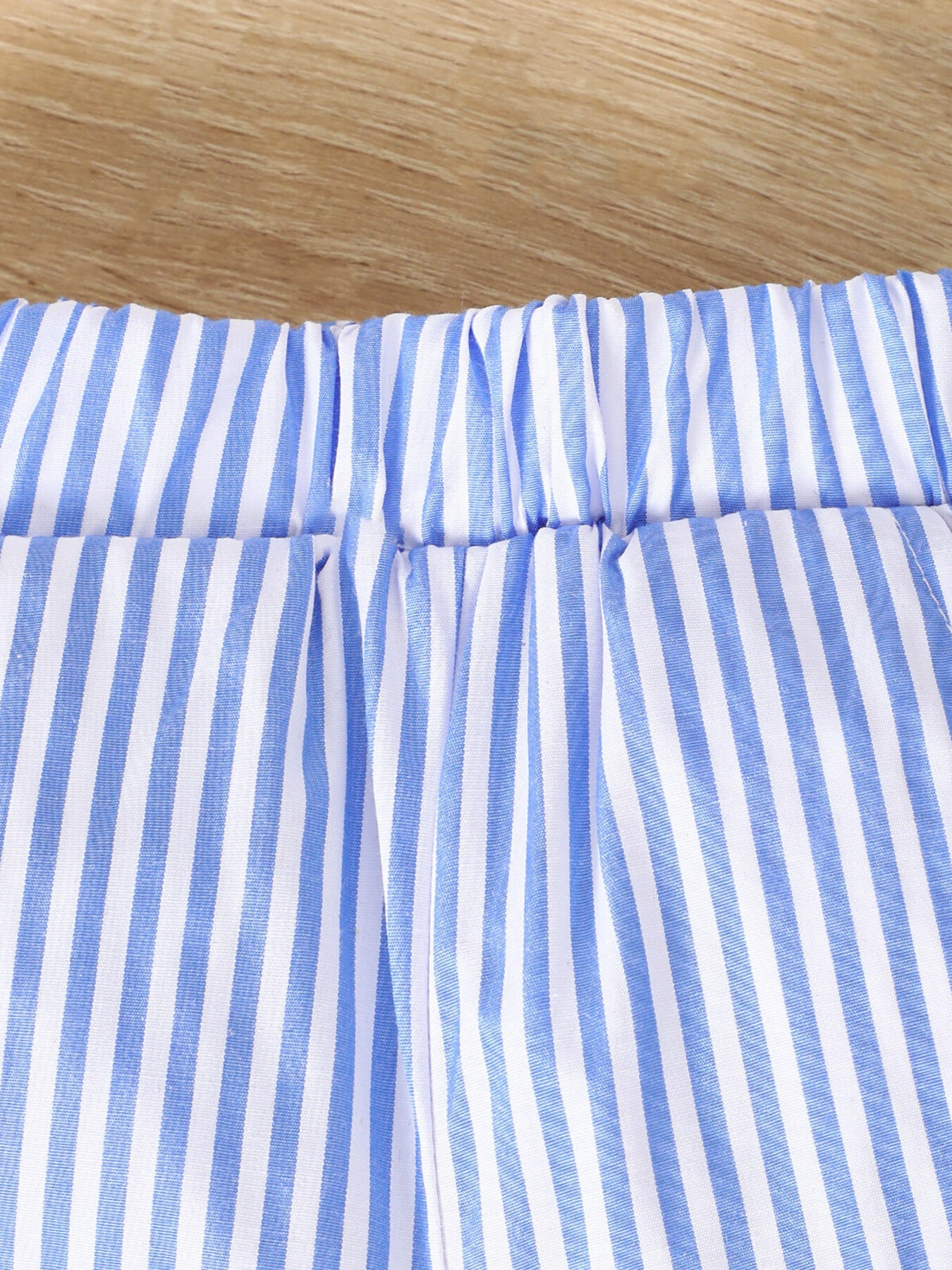 Baby shorts with blue and white vertical stripes and elastic waistband.