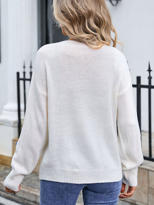 White knit sweater with embroidered bloom appliqué detail on sleeve