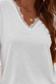 White V-neck tee with lace trim detail and layered necklaces.