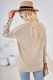 Mocha slouch v-neck top with button cuffs and a relaxed fit.