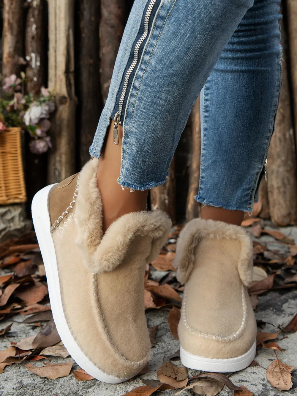 Beige felted slippers with shearling lining and stitch detail.