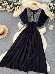 Black embroidered V-neck bohemian maxi dress with flutter sleeves and tie waist.