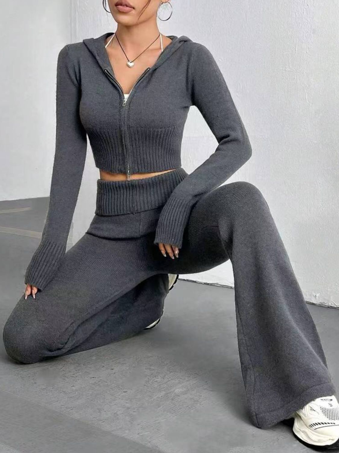 Dark gray ribbed knit flare set with zip-up cropped hoodie and wide-leg pants.