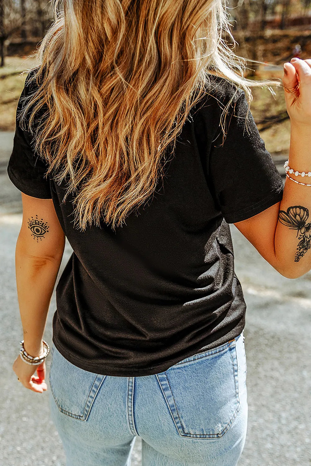 Black t-shirt with short sleeves and a graphic print on the arm.