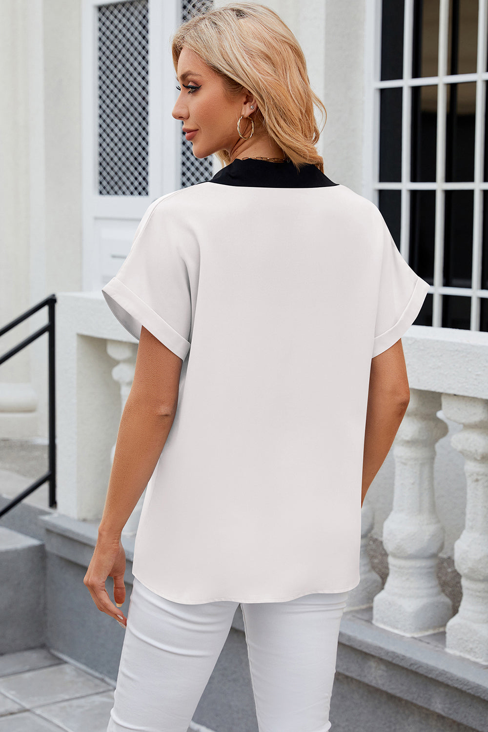 White blouson top with black contrast collar and short cuffed sleeves.