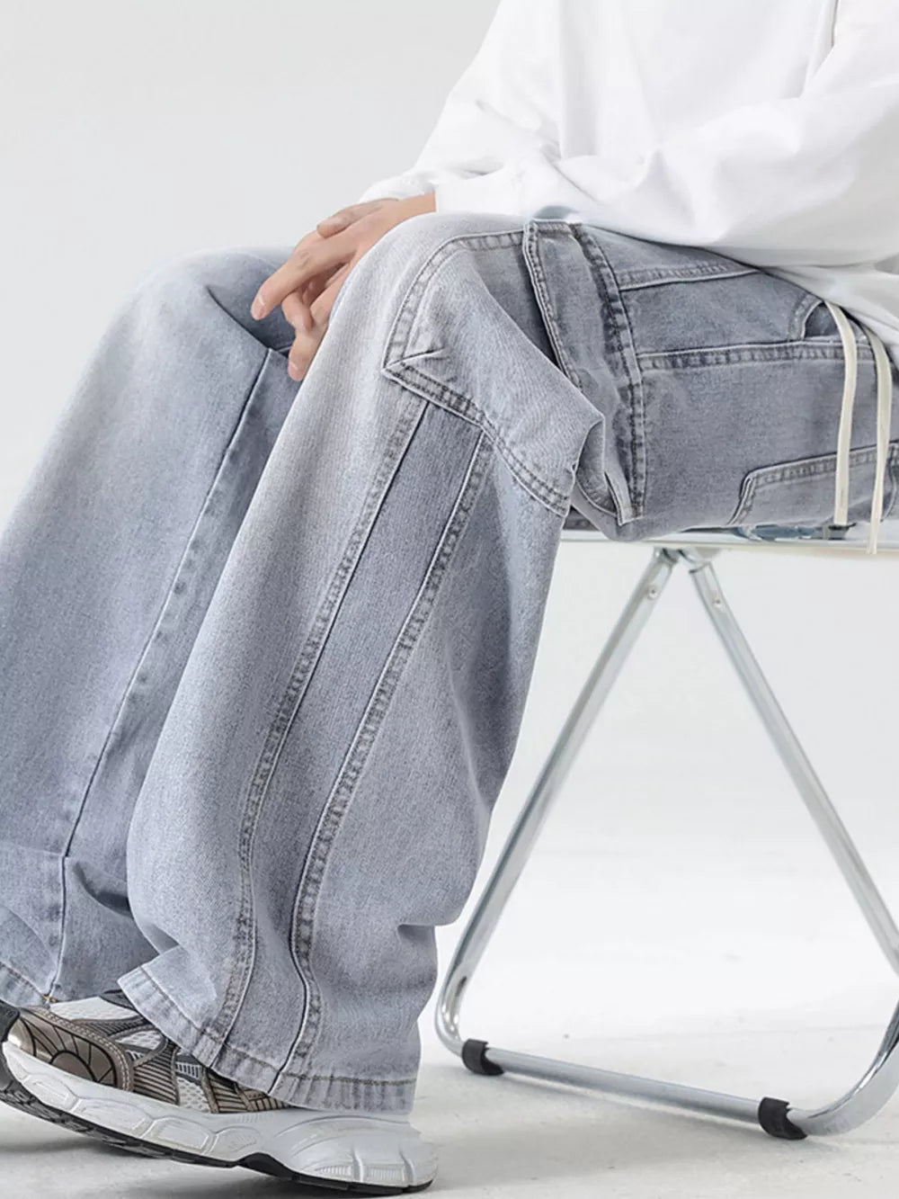 Light blue oversized cargo jeans with drawstring waist and utility pockets.