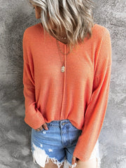 Orange open-knit V-neck sweater with drop shoulders and long sleeves.