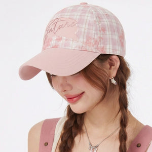 Blush pink plaid baseball cap with embroidered detail and pink brim.
