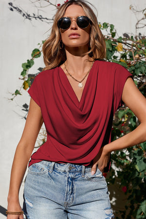Cowl neck cap-sleeve tee in rust, styled with denim shorts.