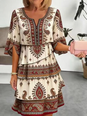 Paisley print tiered mini dress with split sleeves and v-neck in cream with burgundy and brown accents.