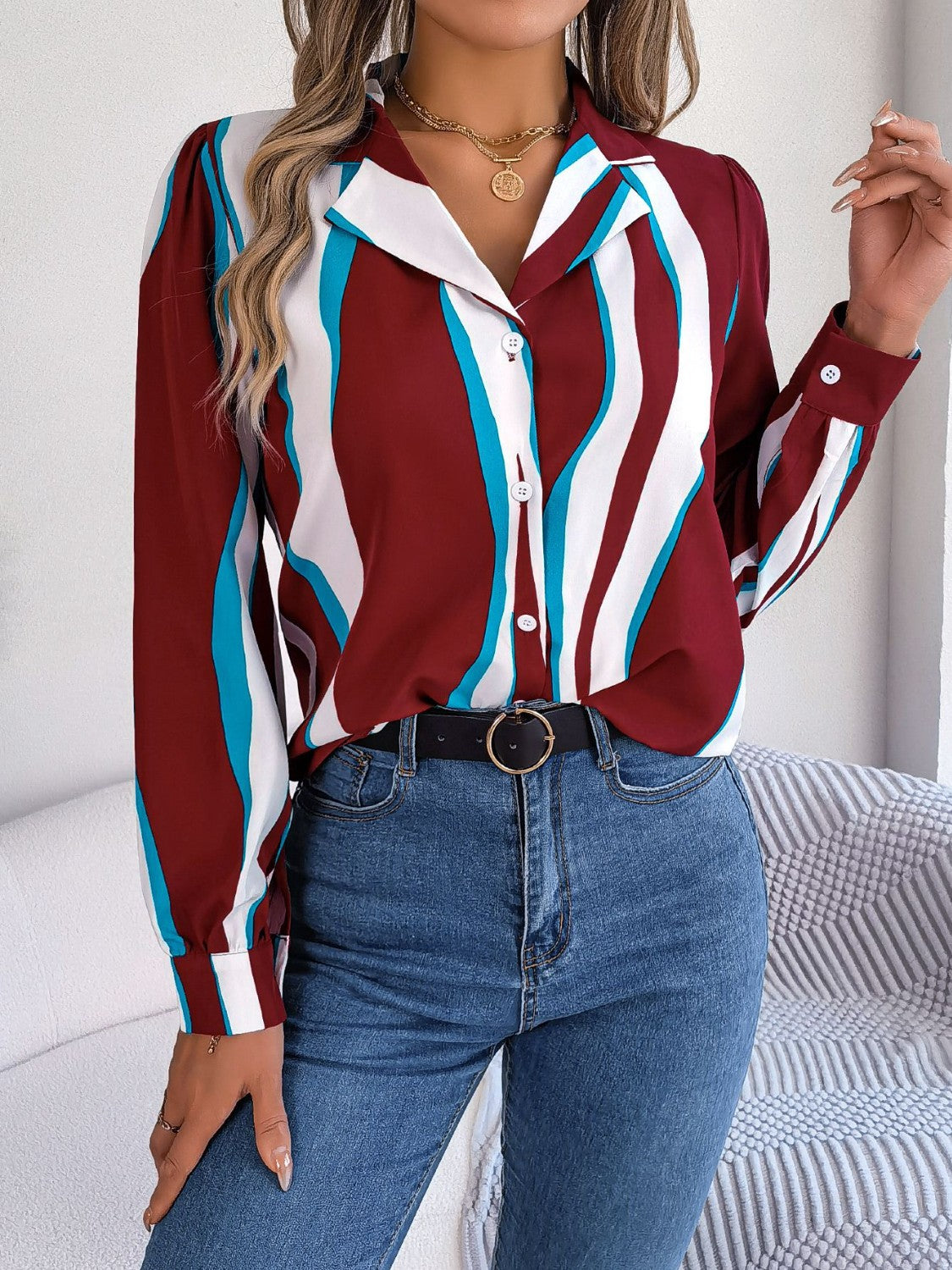 Burgundy collared blouse with wavy white and blue stripes, button front, and long sleeves.