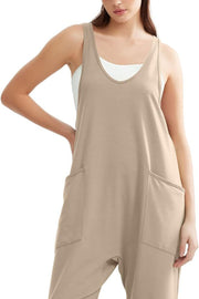 Khaki relaxed fit pocketed jumpsuit with a scoop neck and tank straps, layered over a white tank top.