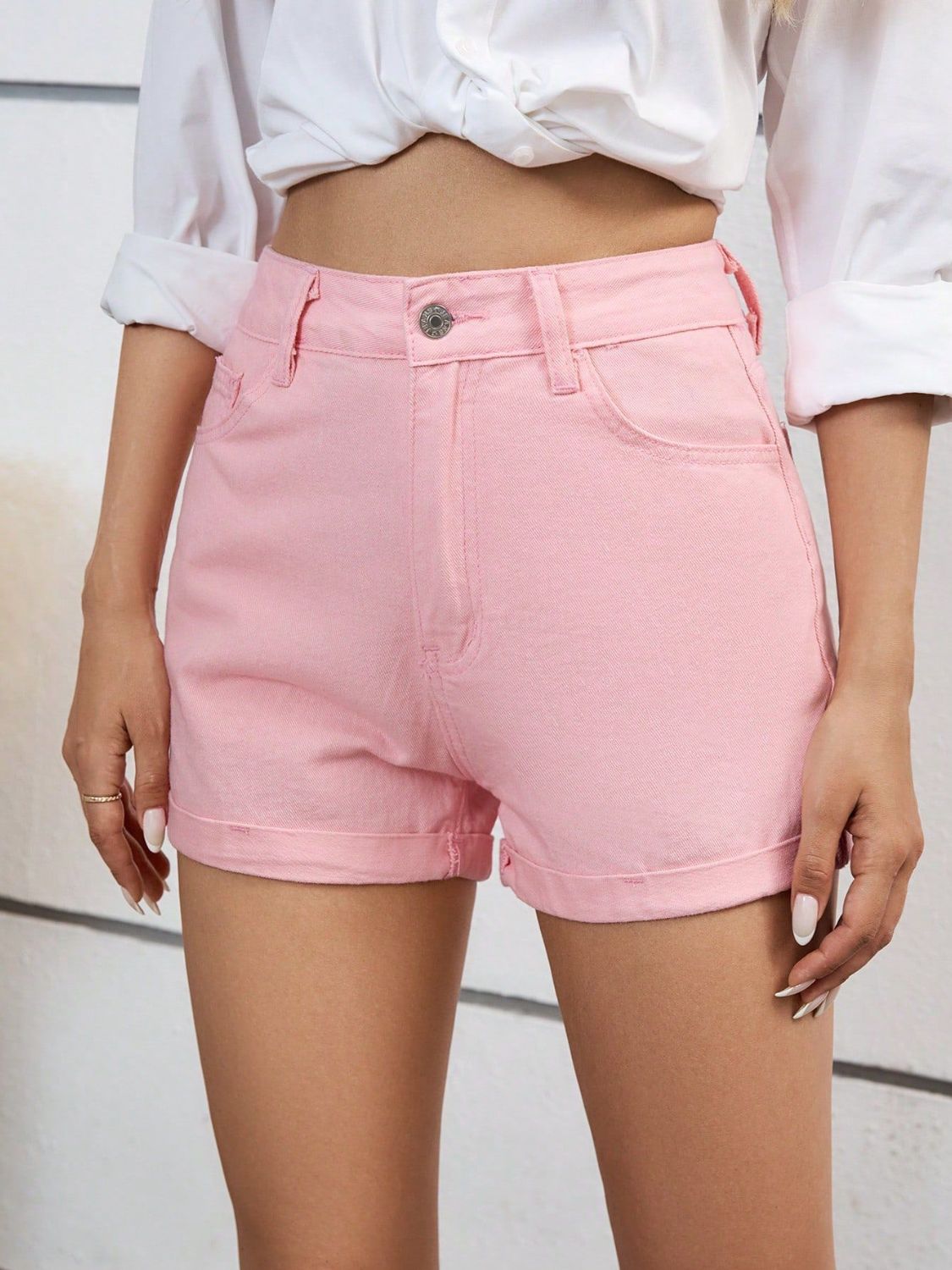 Blush pink denim high-waist shorts with cuffed hems.