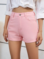 Blush pink denim high-waist shorts with cuffed hems.