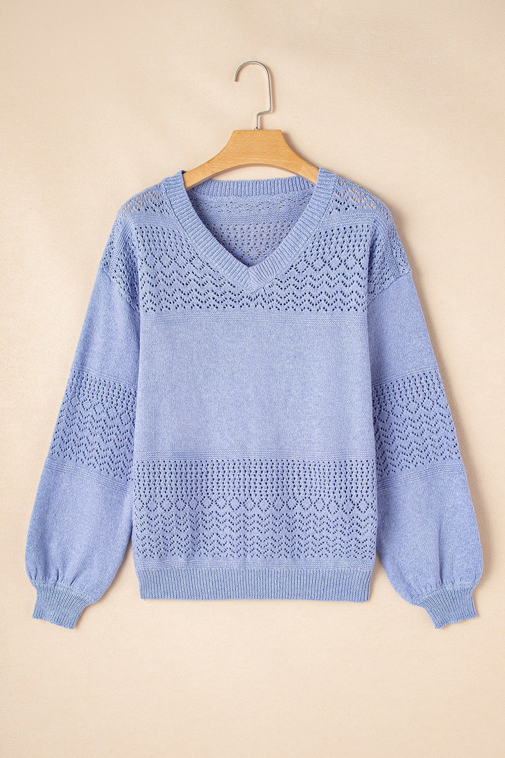 Light blue perforated knit V-neck pullover sweater with balloon sleeves and textured detail.