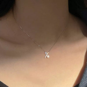 Gold necklace with a delicate percentage sign pendant adorned with tiny crystals and a pearl.