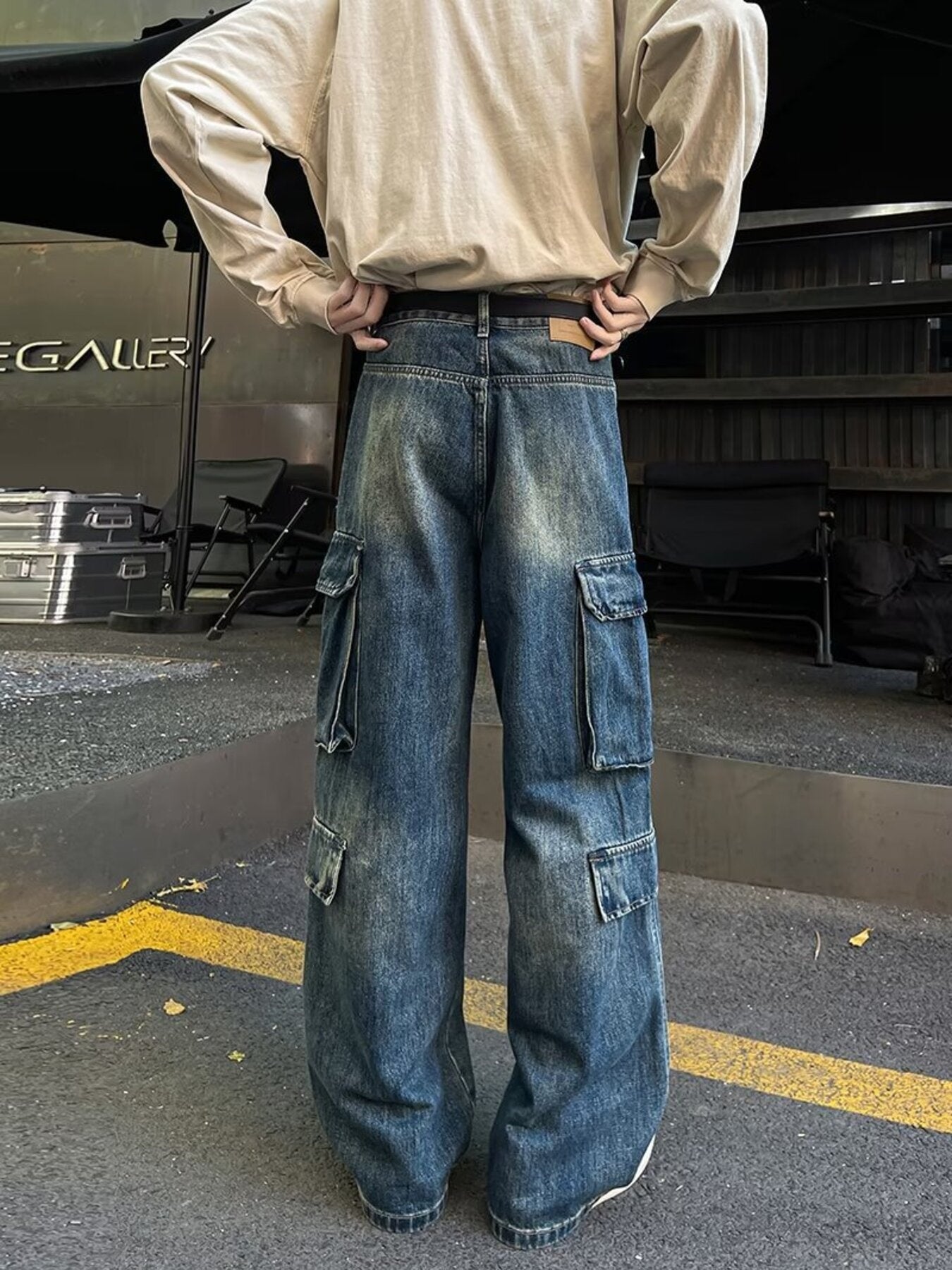 Men's vintage wash blue denim wide-leg cargo pants with multiple pockets.