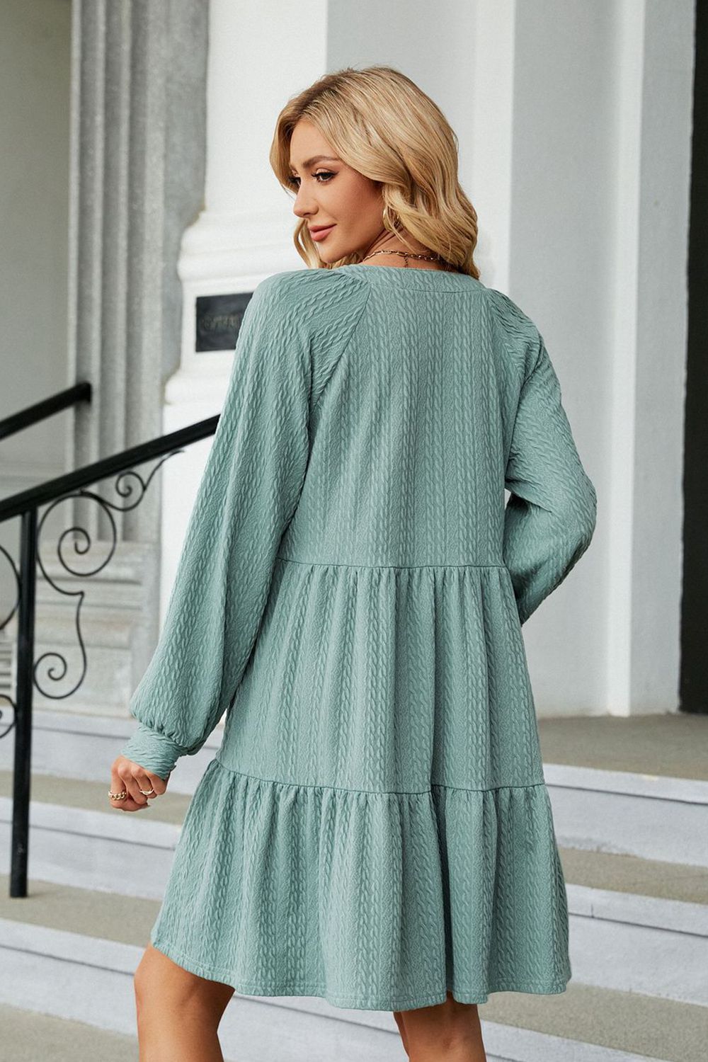 Light green textured babydoll mini dress with voluminous sleeves and tiered skirt.