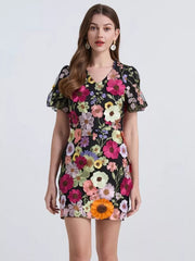Embroidered floral mini dress in black with puff sleeves and V-neck.