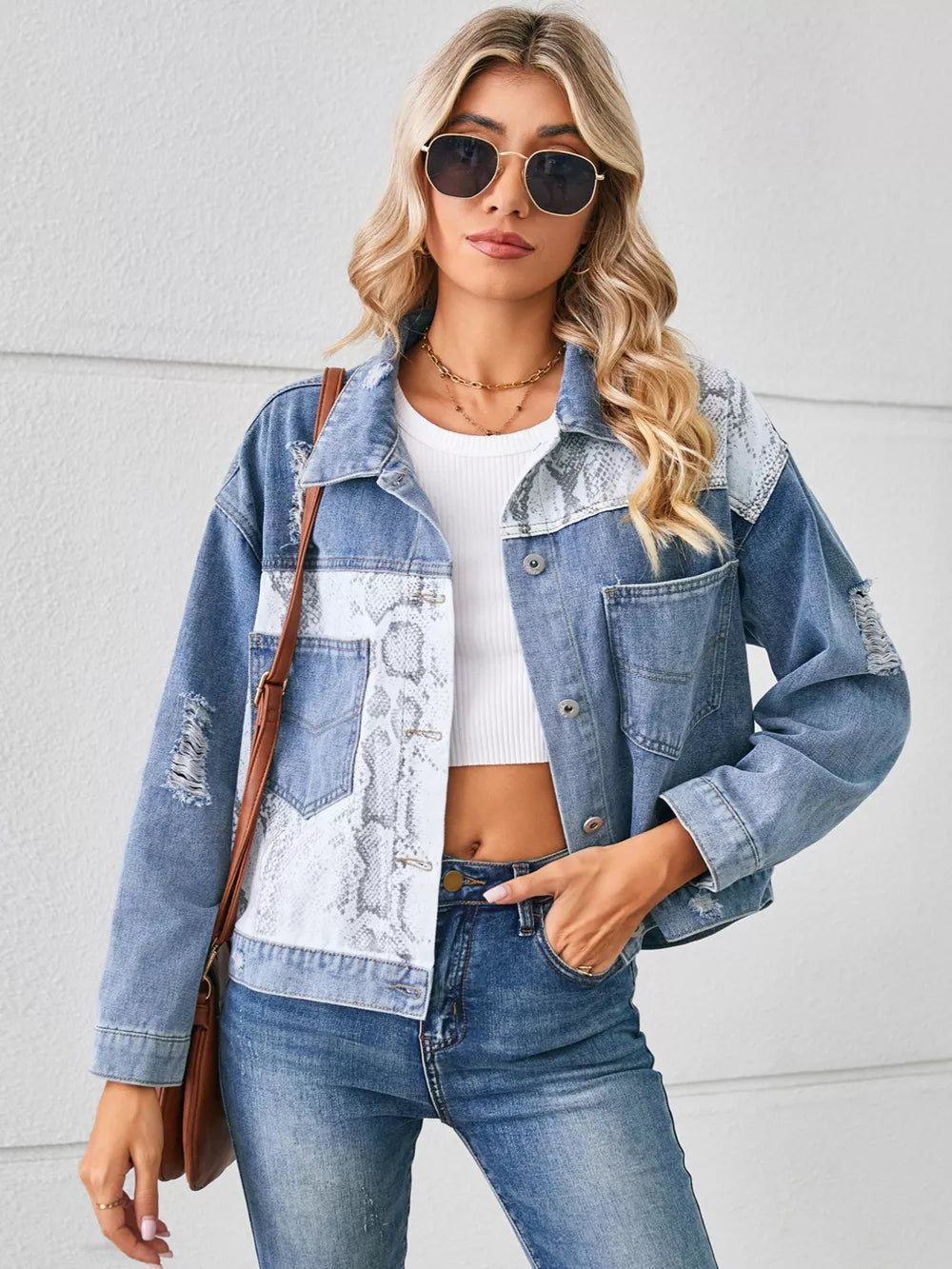 Denim trucker jacket with python pattern panels and distressed details.