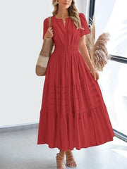 Red V-neck tiered maxi dress with smocked waist and short sleeves, styled with a straw bag.